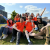 A group of young people attending the Leadership for Life conference 2024 sit on a sunny hillside and pose for a photo